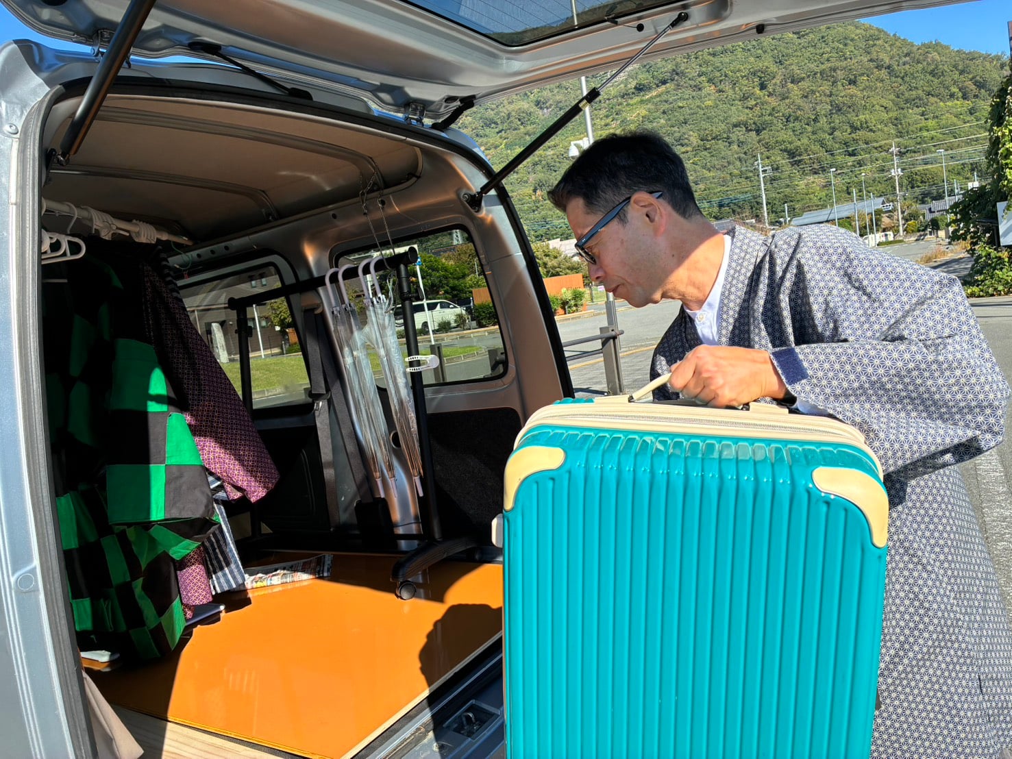 A tour guide safely loading a guest's suitcase into the vehicle trunk