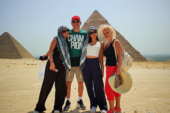 Tourists group photo with the Pyramids of Giza in the background.