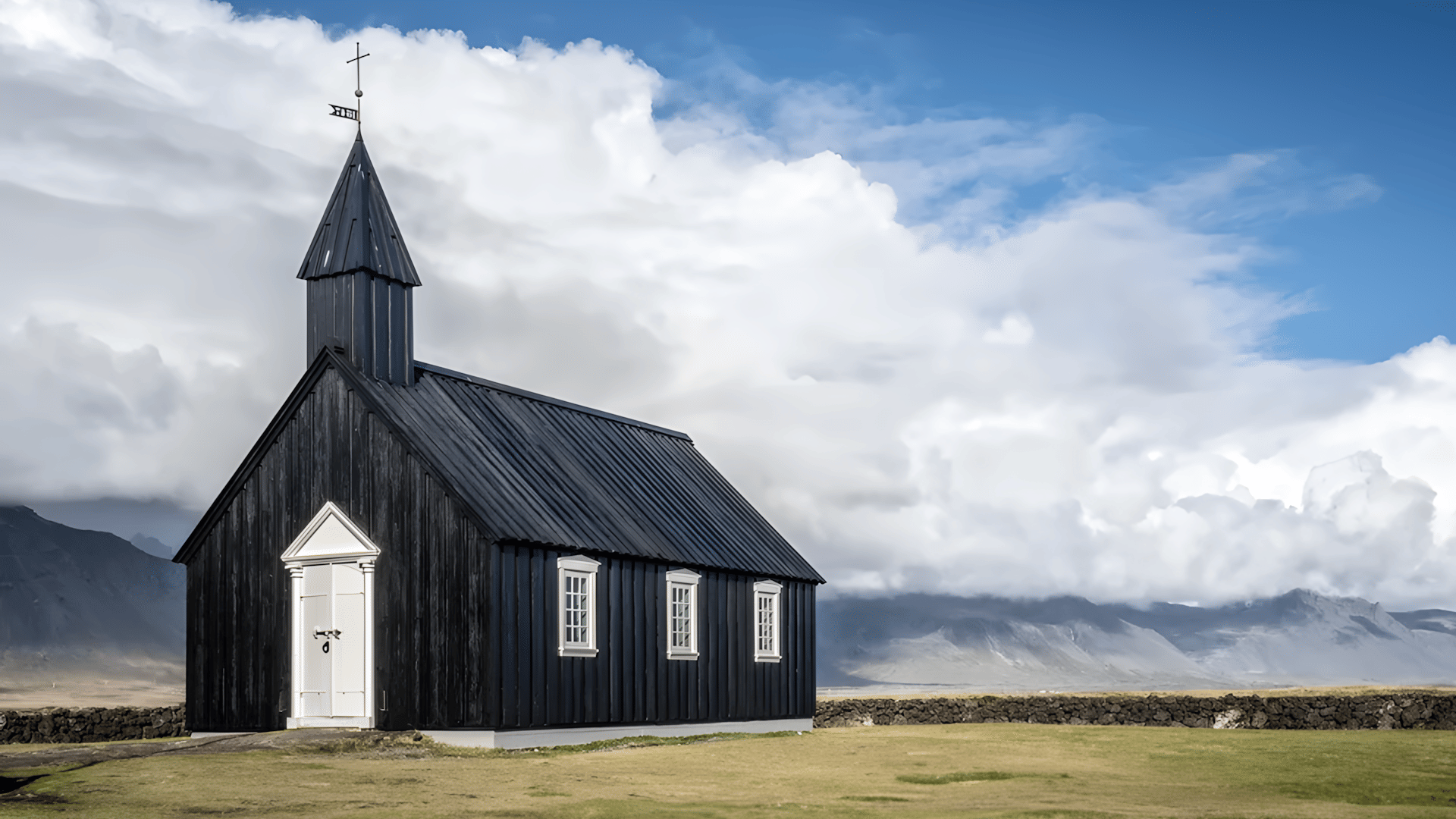 A black church with mountains in the background