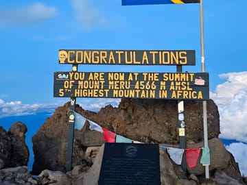 Reaching the summit of Mount Meru, the 5th highest peak in Africa.