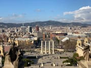 View from Montjuic hill over Barcelona in the direction of Plaça Espanya. You overlook the city with another mountain range in the back.