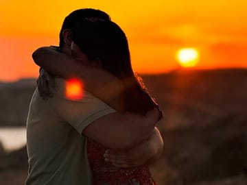 A happy couple embracing on a private boat in Malta at sunset, capturing the magical moment right after she said yes to his romantic proposal.