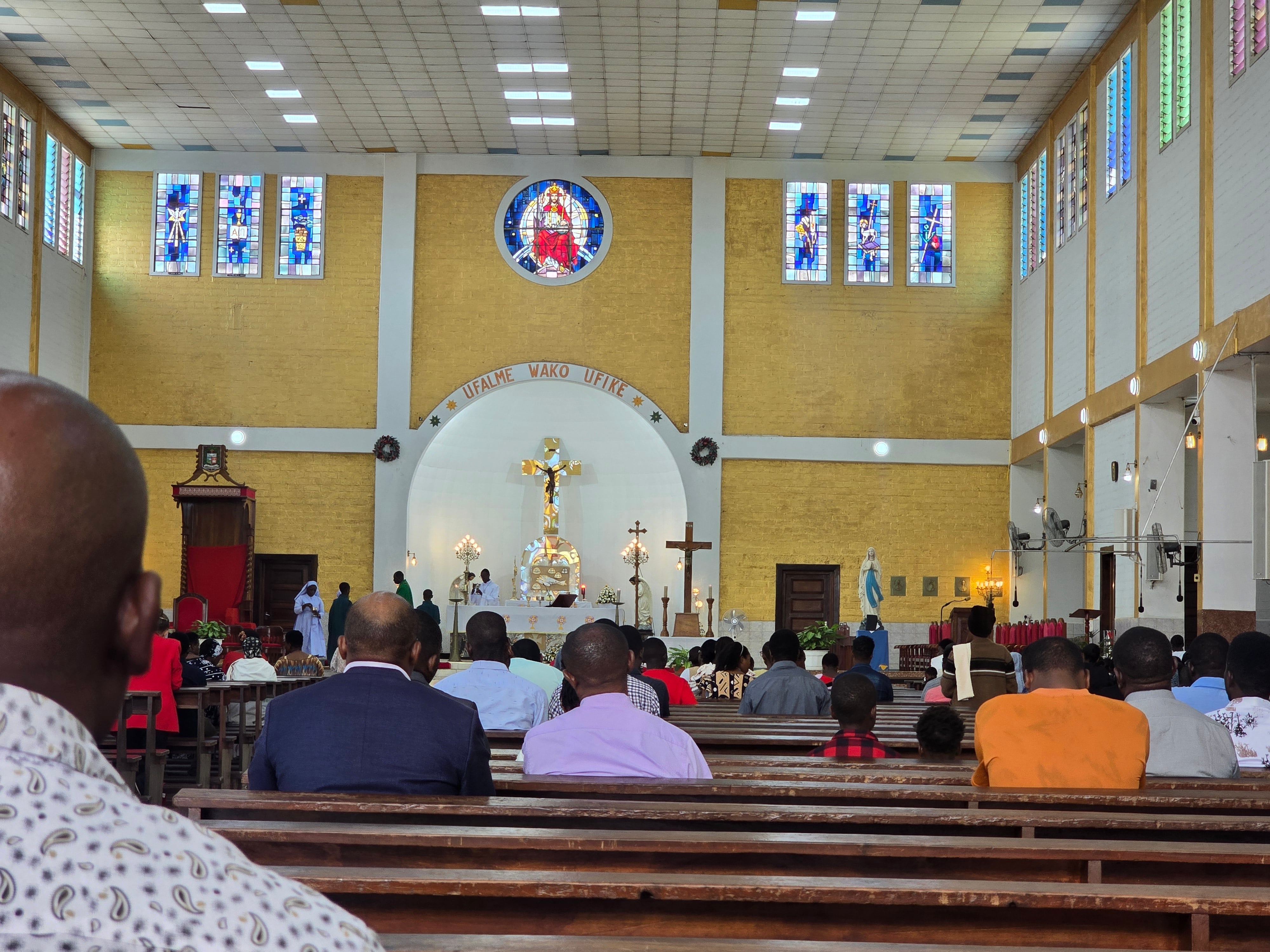 Inside view of Christ the King Cathedral in Moshi showing the spacious sanctuary, high ceiling, and wooden pews.