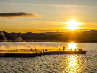 People enjoying the warm waters in the floating geothermal pools at Vök baths during sunset