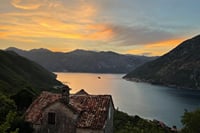 Stone house with sunset views over Perast and the iconic islands of Our Lady of the Rocks and St. George in the Bay of Kotor.