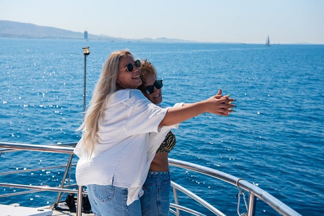 Two passengers enjoying the sea breeze at the boat’s bow