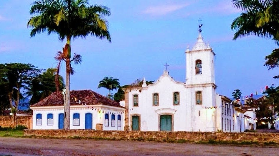 Igreja colonial e casas tradicionais no centro histórico de Paraty ao entardecer, Costa Verde, Brasil.
