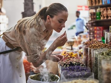 Guest smelling Spices at the spice souk in Old Dubai during their layover in dubai.