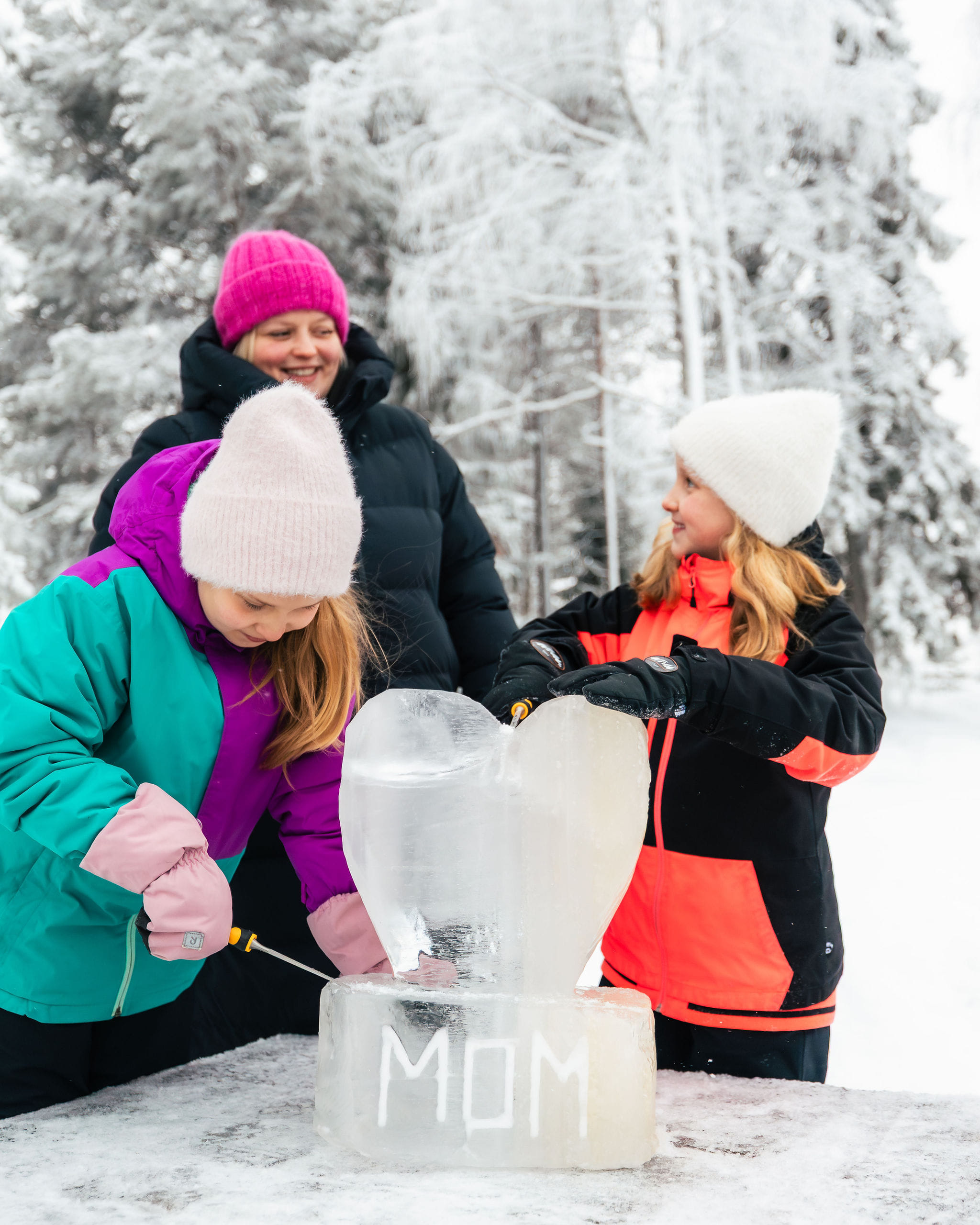 A family sculpting an ice block with sculpting tools