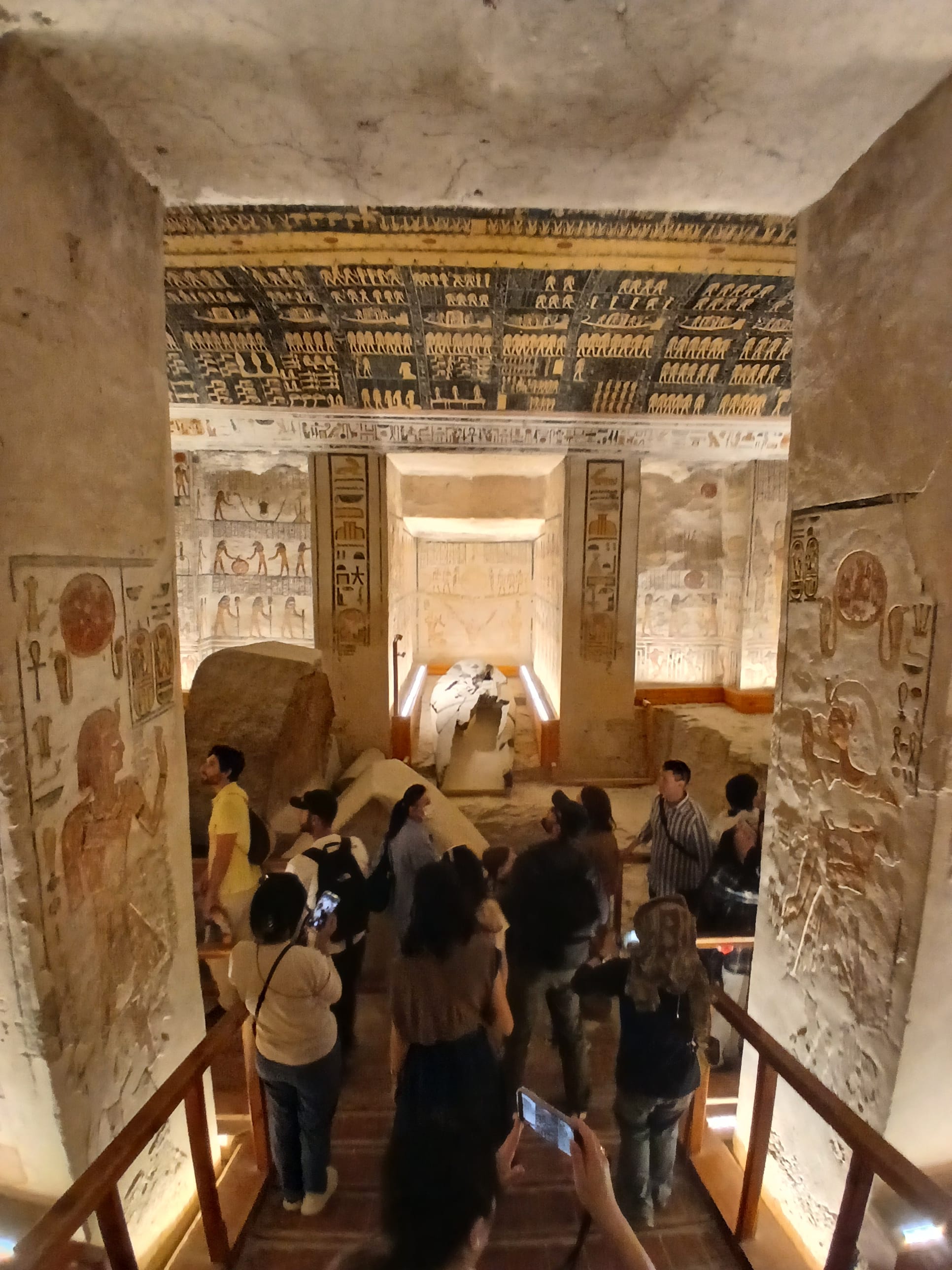 A view looking into a decorated chamber within an ancient Egyptian tomb, likely Ramesses VI (KV9). The high ceiling is completely covered in