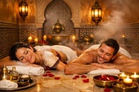 A smiling couple enjoying a relaxing full-body massage in a dimly lit, candlelit spa.