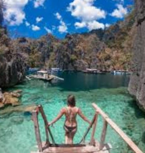 Travelers enjoying the Coron Ultimate Tour, featuring lagoons, white-sand beaches, coral reefs, and stunning limestone cliffs in Palawan.