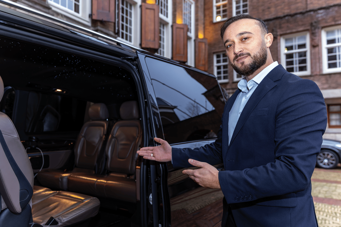 Private driver in Amsterdam next to luxury vehicle offering personalized city tour service