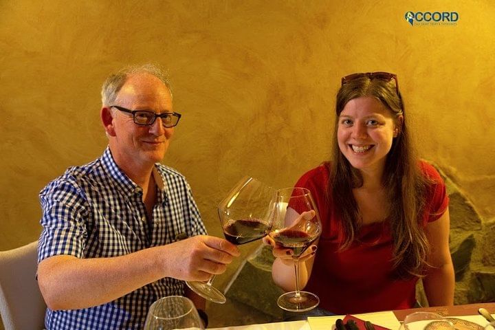 View of two people enjoying a glass of red wine 