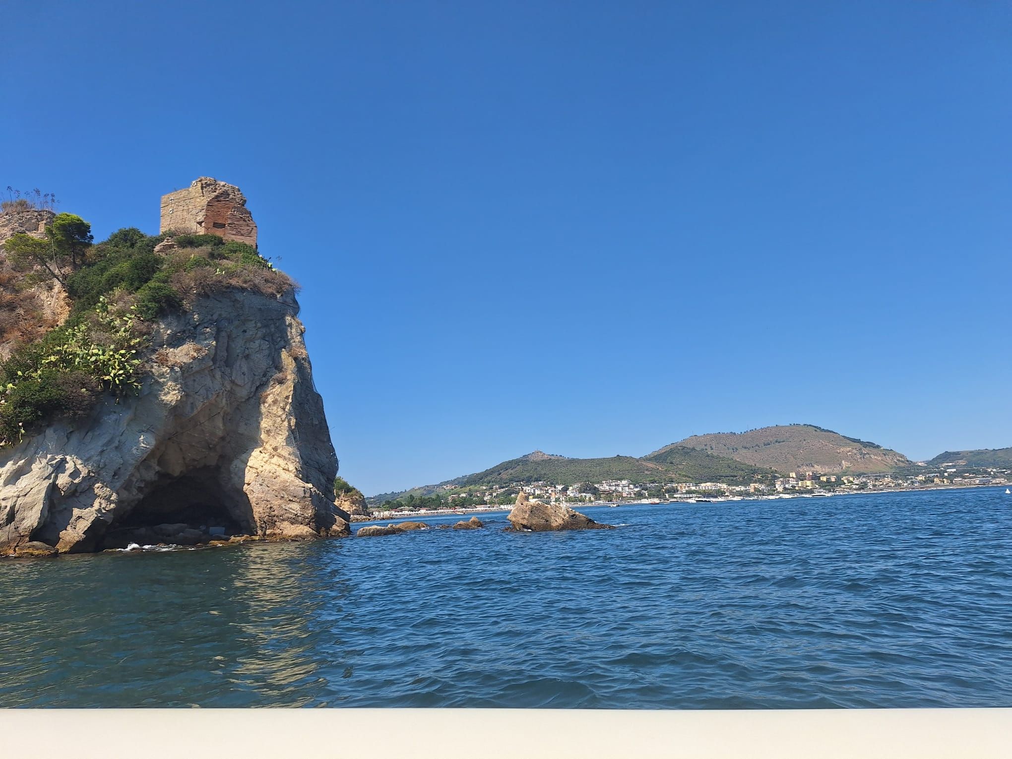 A panoramic photo from the sea of Punta Epitaffio, the promontory in front of the Park of Baia, with the coastline in the background