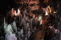 Interior of a lava cave with rock formations and illuminated pathways in Iceland