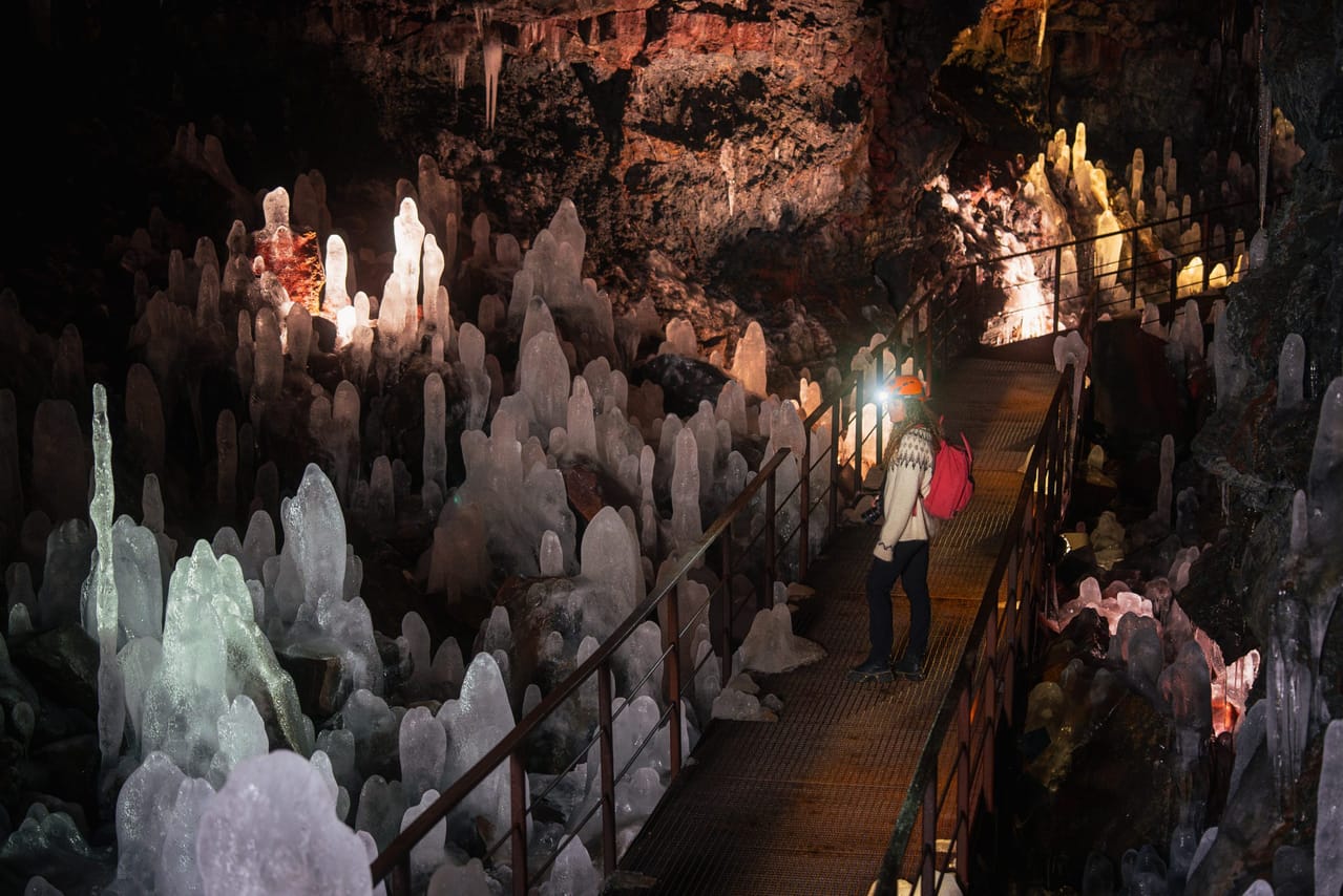 Interior of a lava cave with rock formations and illuminated pathways in Iceland