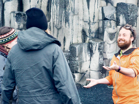 Guide explaining the basalt formation at Reynisfjara beach