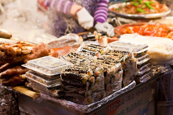 Experience authentic Korean street food at Gwangjang Market —A vendor at Gwangjang Market selling traditional Korean street food such as pancakes and seafood.