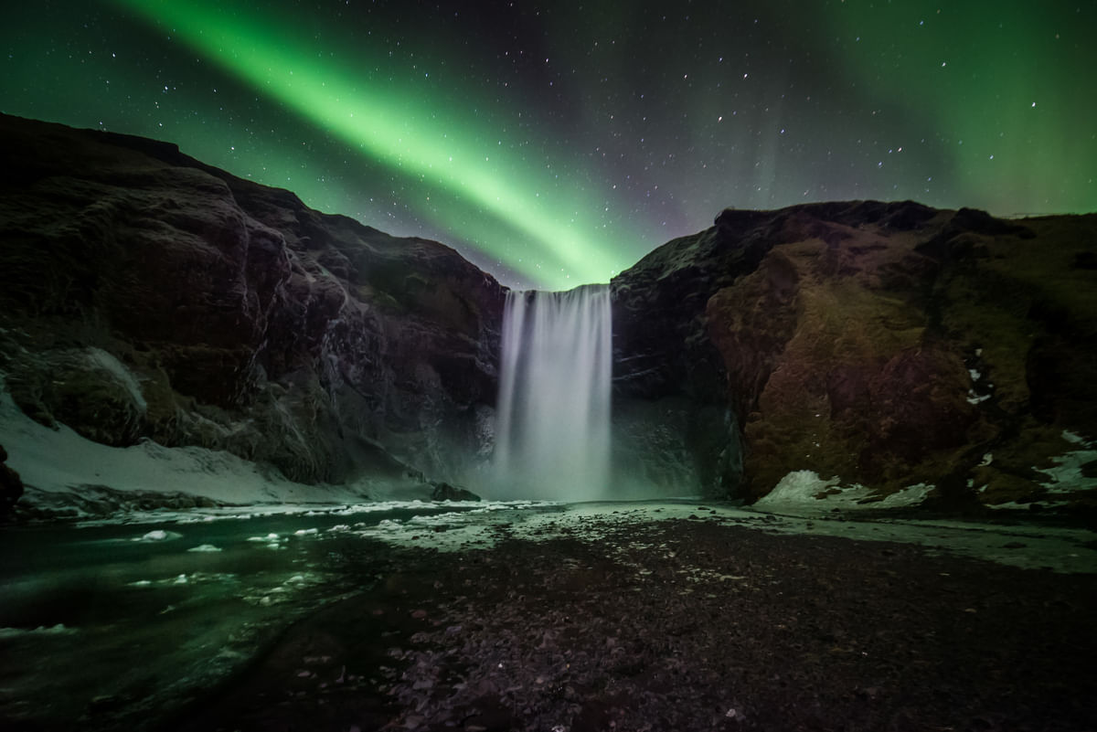 Beautiful northern lights over Skógarfoss waterfall Iceland