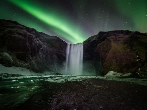 Beautiful northern lights over Skógarfoss waterfall Iceland