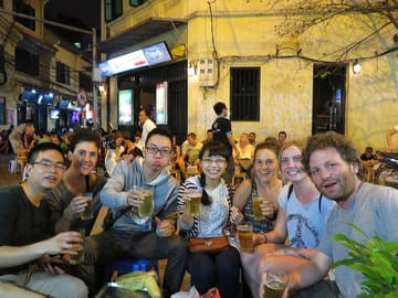 A group of friends is happily enjoying food in Hanoi.