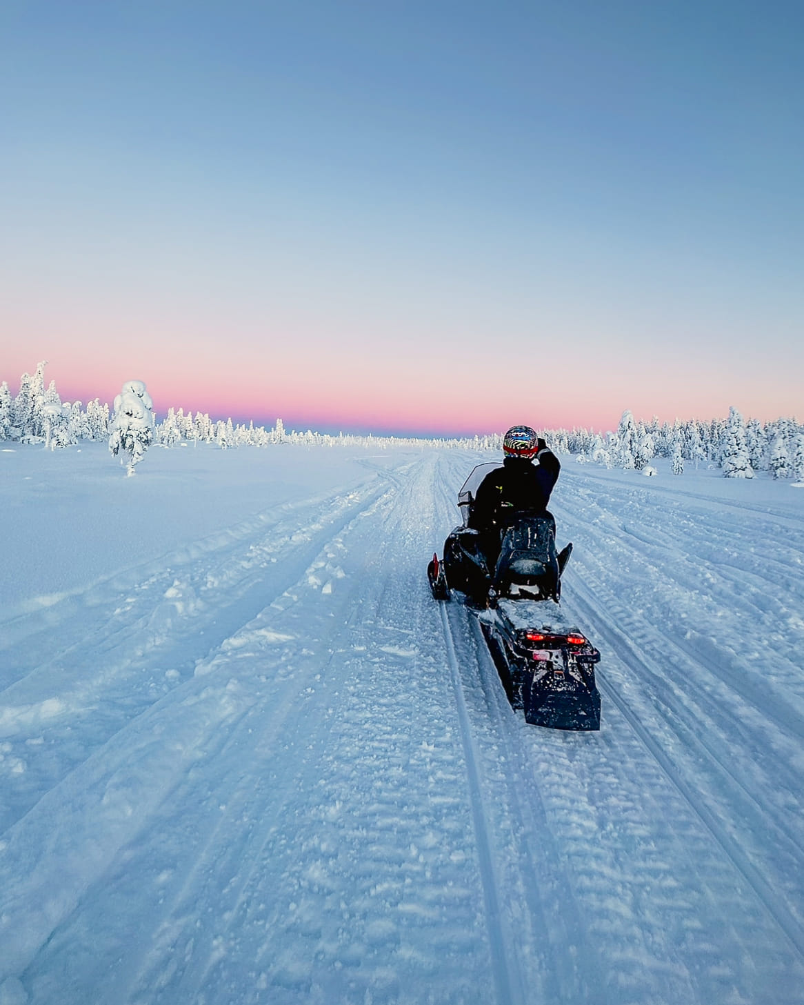 Snowmobiler riding through the snowy landscape of Rovaniemi with StayLapland.