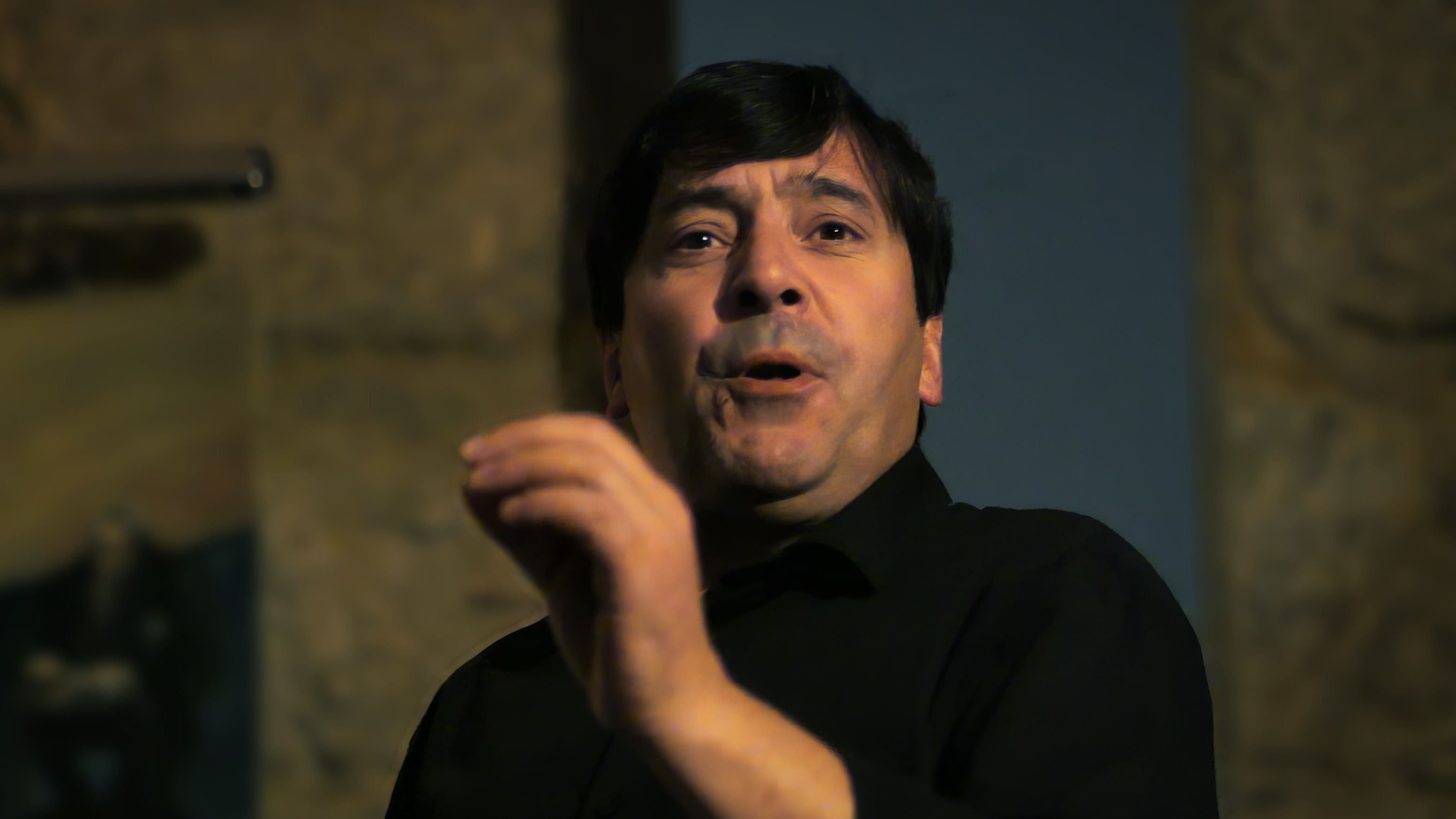 Image of a male Fado singer performing with intensity at a local restaurant, part of Cooltour Oporto's Fado Dinner Show with Night Tour