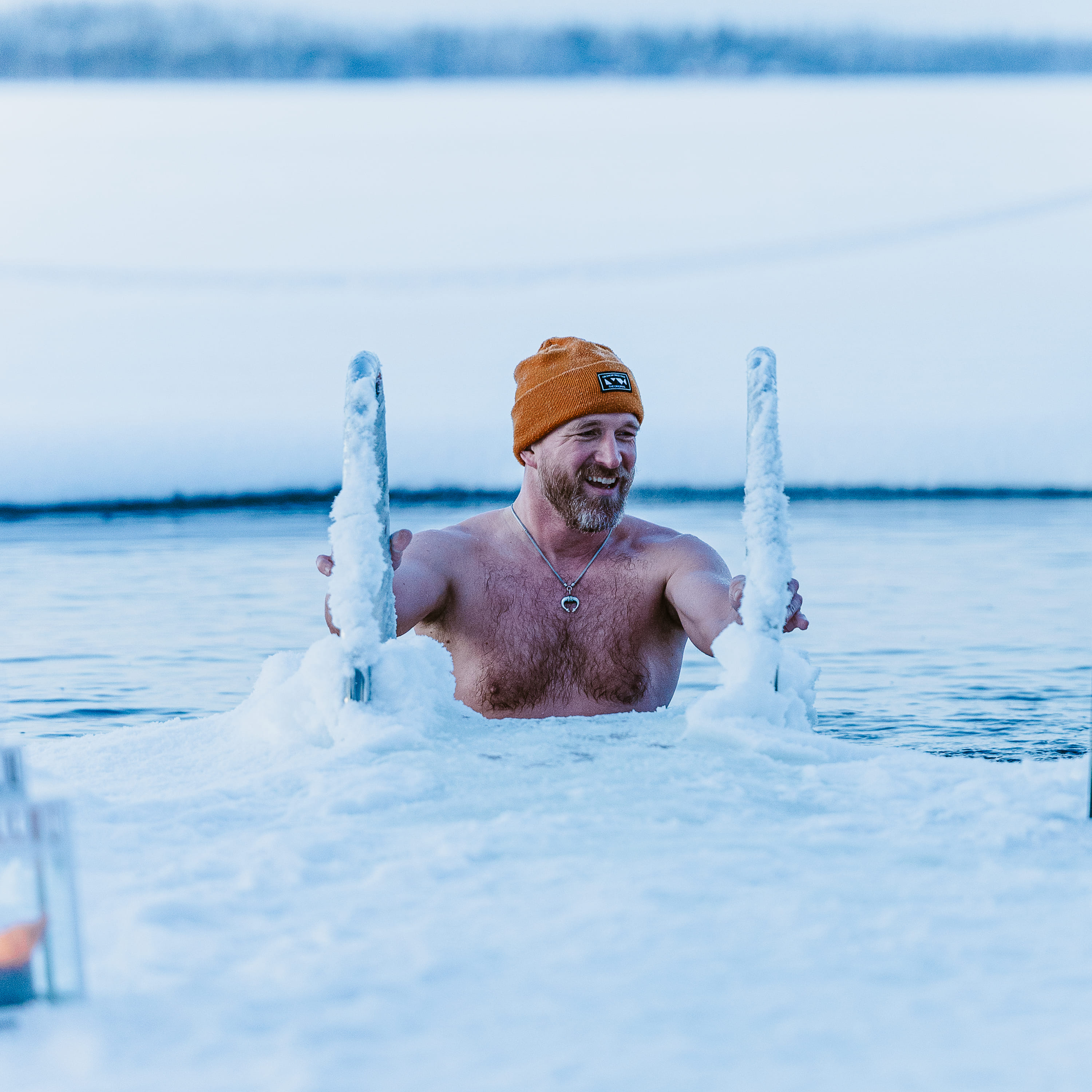Man descending to cold water to do ice swimming.