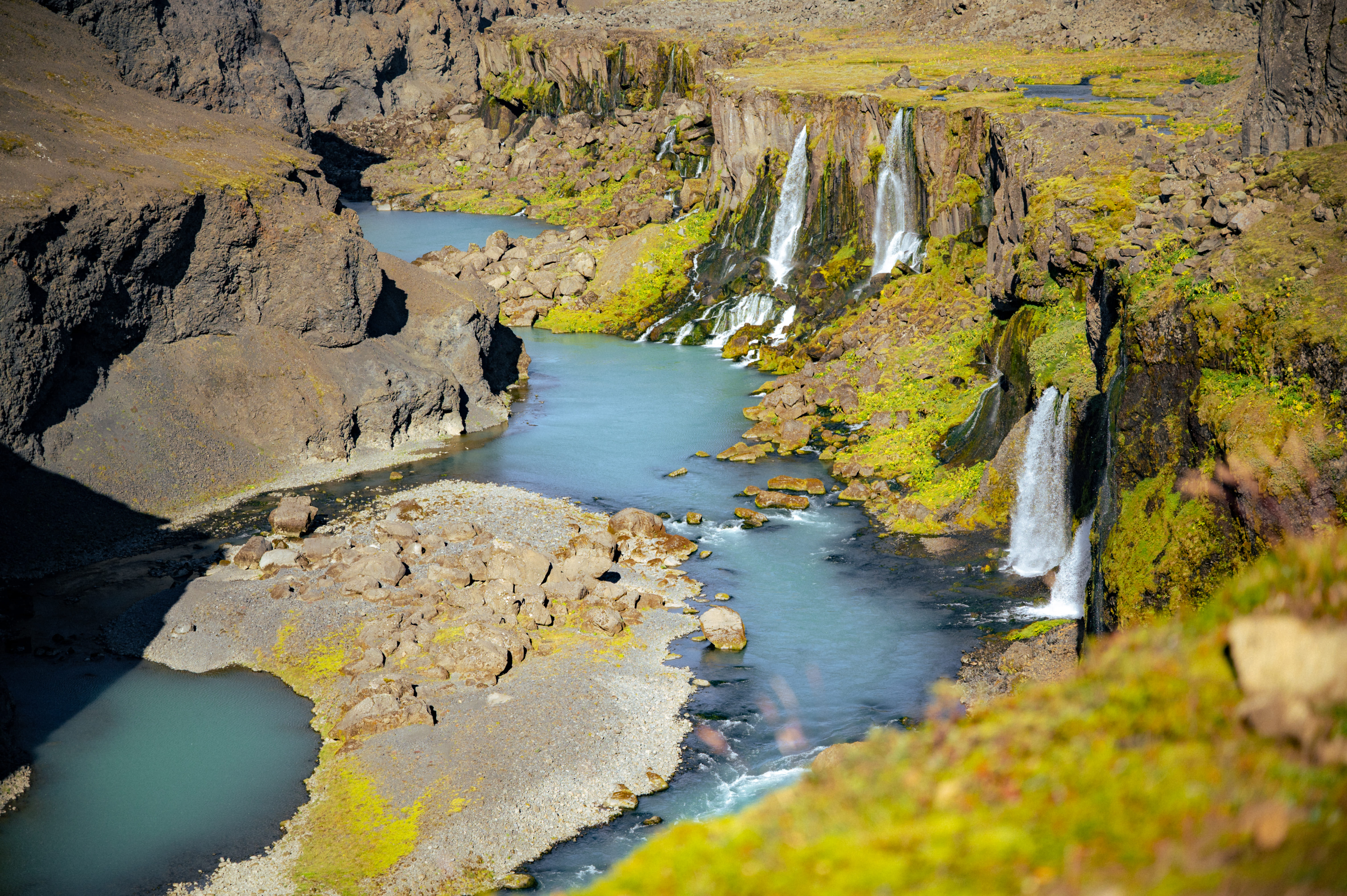 The hidden canyon of Sigöldugljúfur with numerous waterfalls flowing into blue water