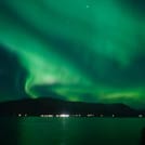 Tour passengers photographing the Northern Lights from a boat deck