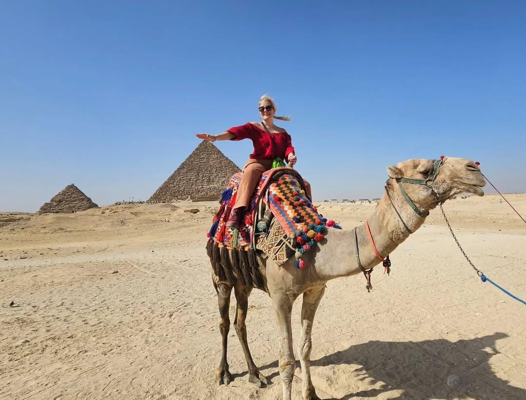 Traveler enjoying camel ride across desert plateau, experiencing camel photography and Egypt sightseeing highlights.
