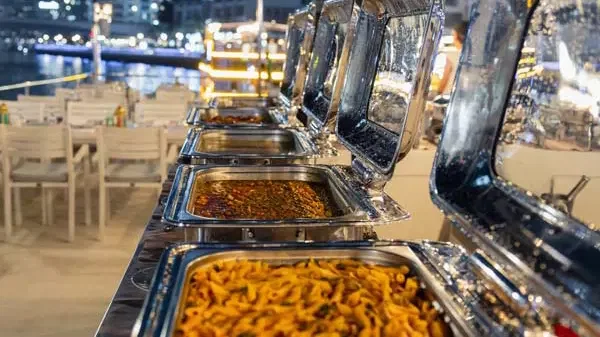 A row of open buffet warmers displays pasta and other dishes on a dining deck at Alexandra Sea Lounge.