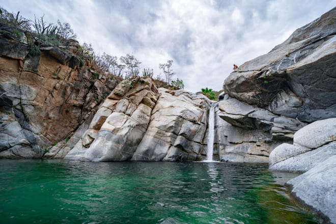 Sol de Mayo waterfall and natural pool surrounded by granite canyon walls near Los Cabos