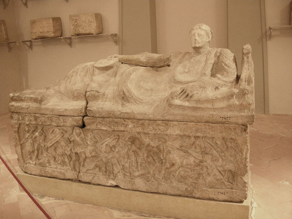 View of a stone Etruscan Sarcophagus with the sculpture of the buried person on top of it.