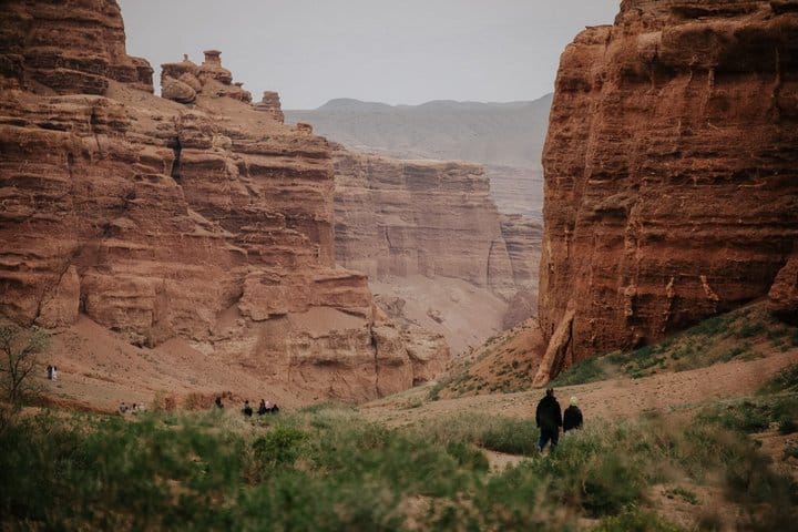 Deep canyon with orange and red sandstone formations under blue sky