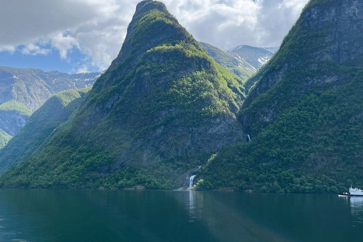 Steep green mountains and waterfalls rising above Nærøyfjord