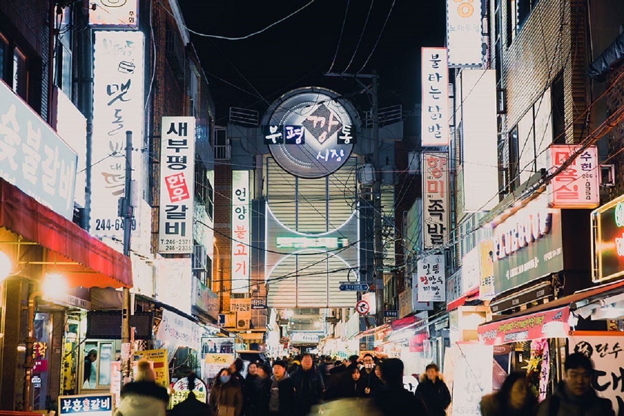 The illuminated entrance sign of Bupyeong Kkangtong Market in Busan at night.