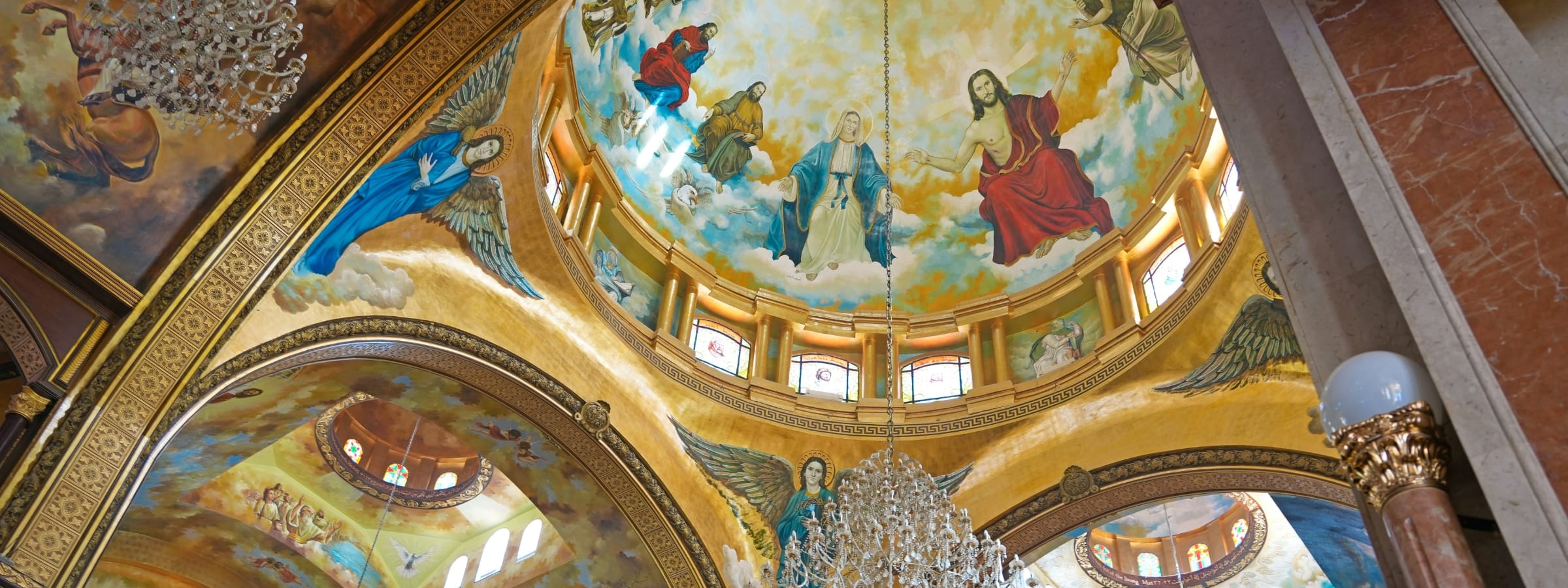Close-up of the stunning, colorful Coptic Christian fresco art and chandeliers on the dome of Heavenly Cathedral.