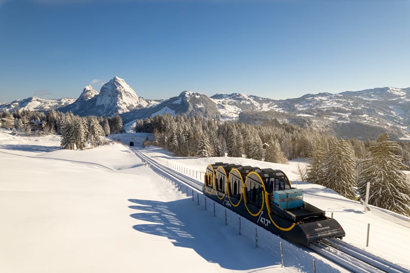 O funicular do Stoos na neve, com os picos dos Mythen ao fundo.