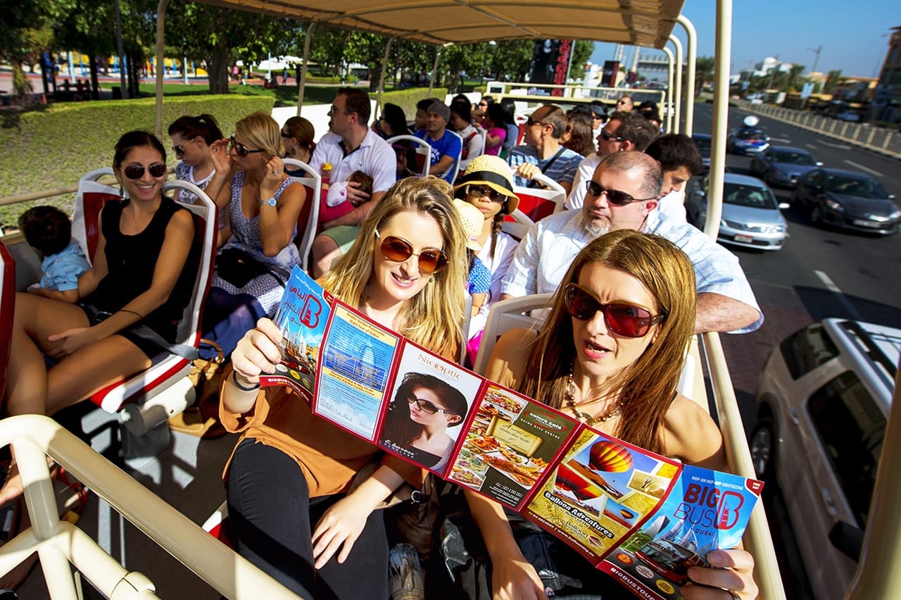 "A group of tourists takes in the sights of Dubai from the Big Bus, making their visit a memorable and enjoyable experience."