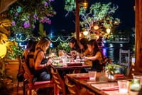 An intimate riverside setting — Private table of six enjoys the magic of SecretEATS, with Hoi An’s iconic lanterns glowing in the background.