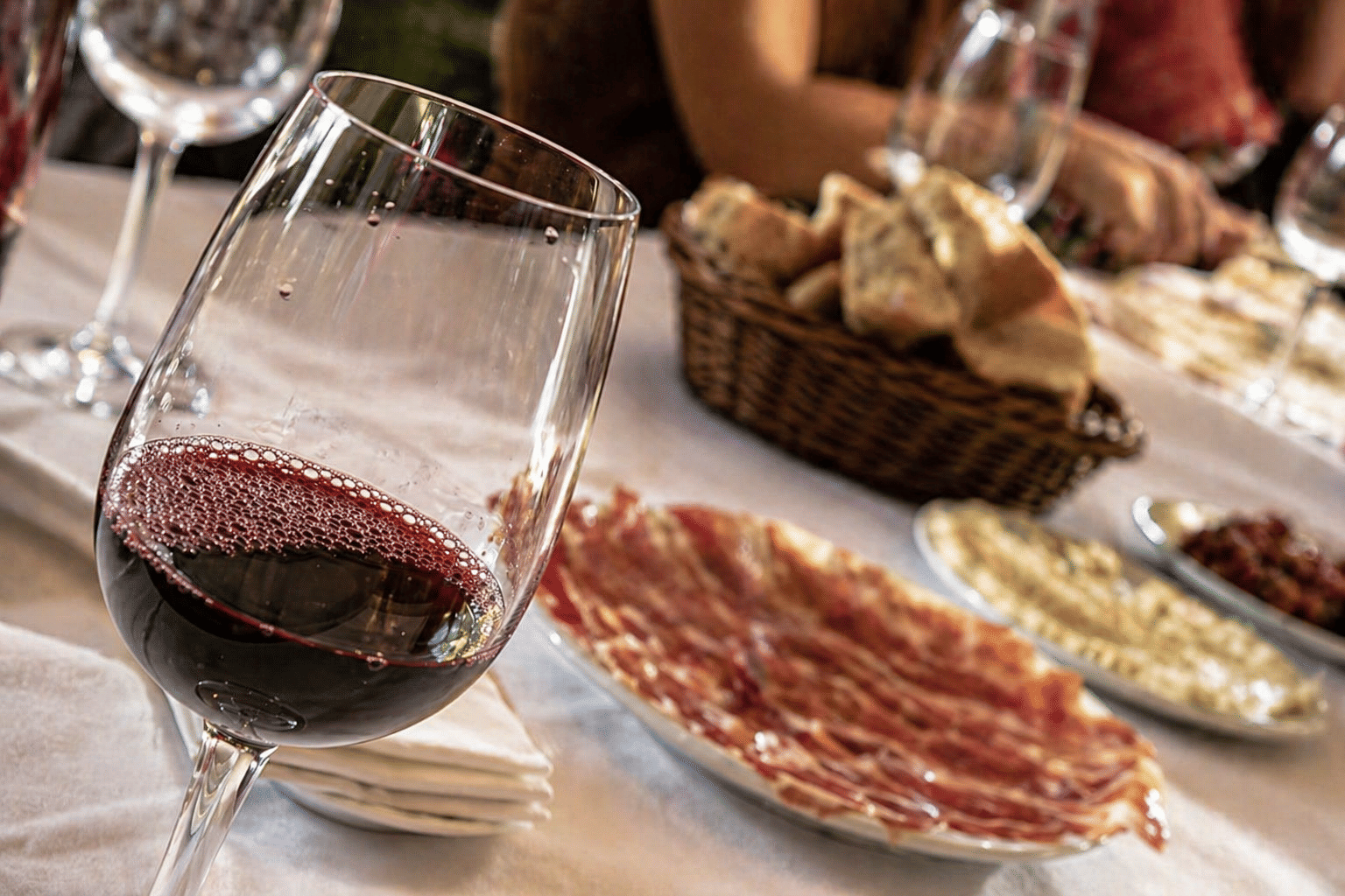 Glass of red wine with Spanish cured ham and local food pairings during a tasting experience in Valencia, Spain