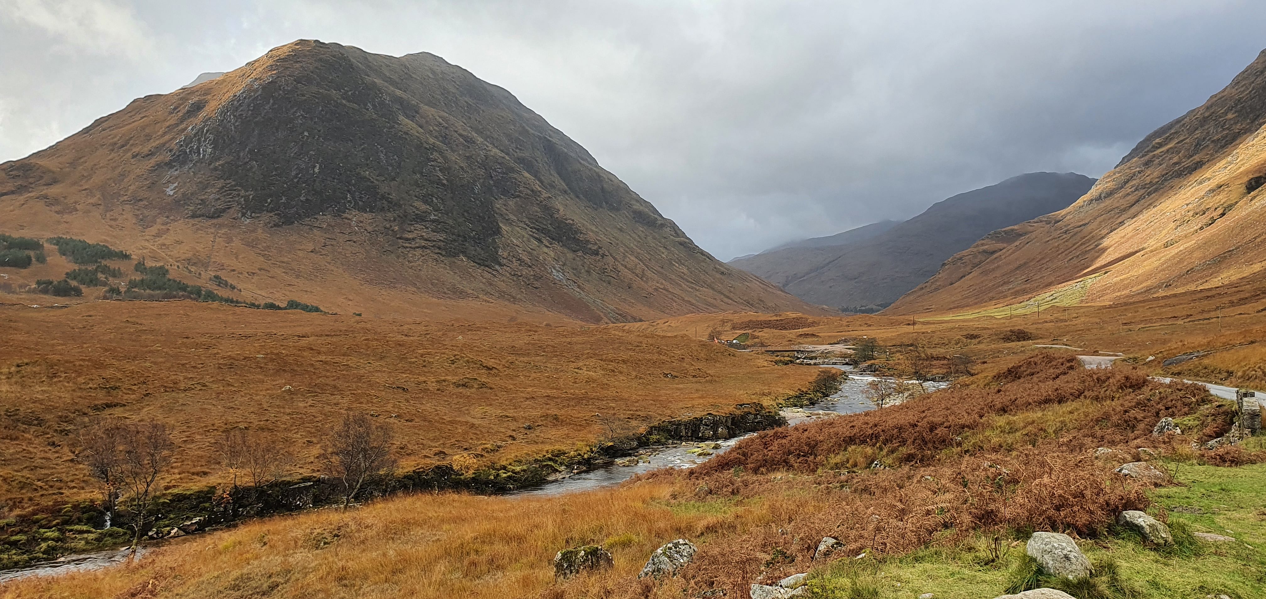 Autumn photo of Glen Etive in the Scottish Highlands. The mountainous glen is covered in golden-brown fern and has a river flowing.