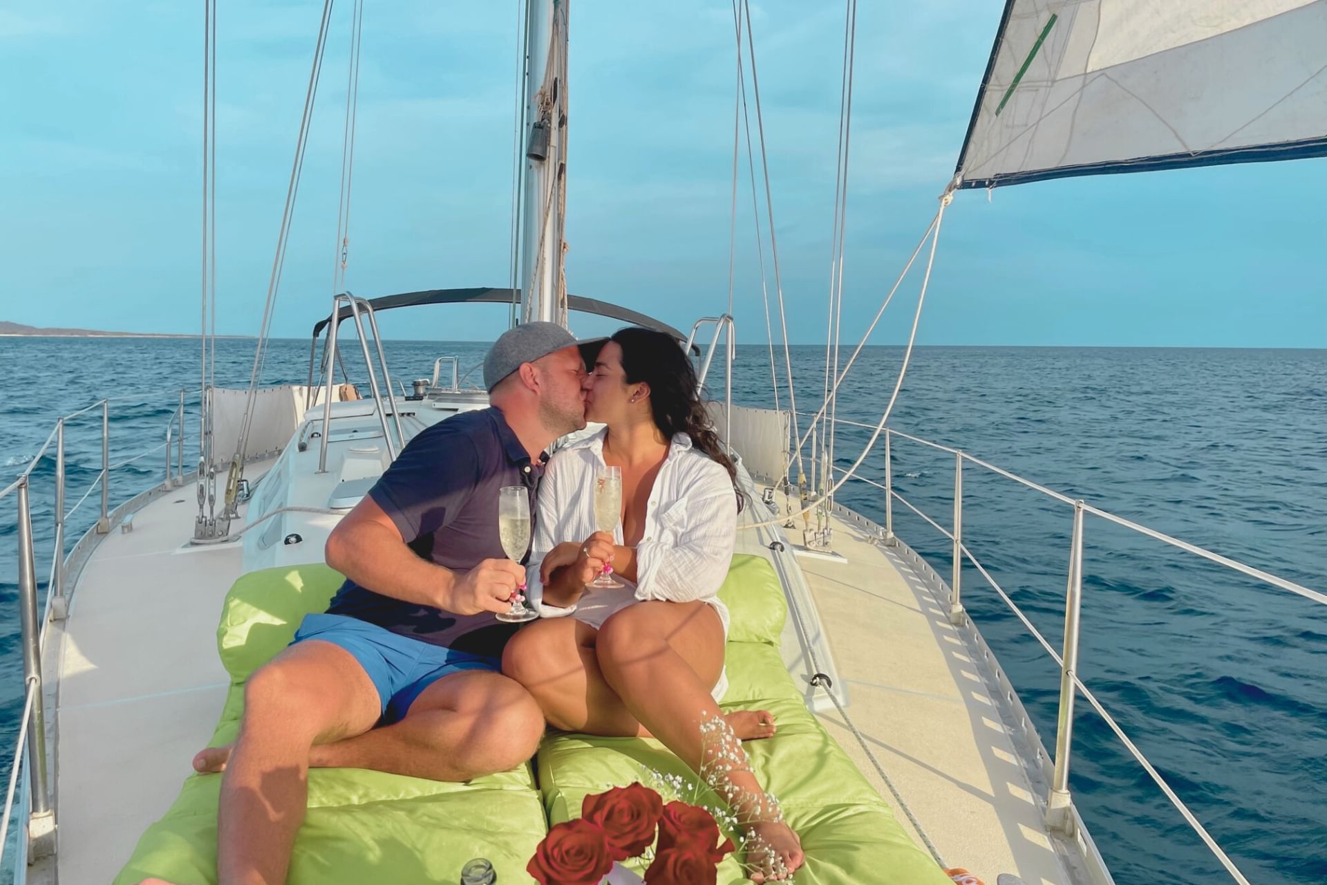 Happy couple celebrating engagement at private romantic tour Maxie Sailing Curacao on deck at sunset