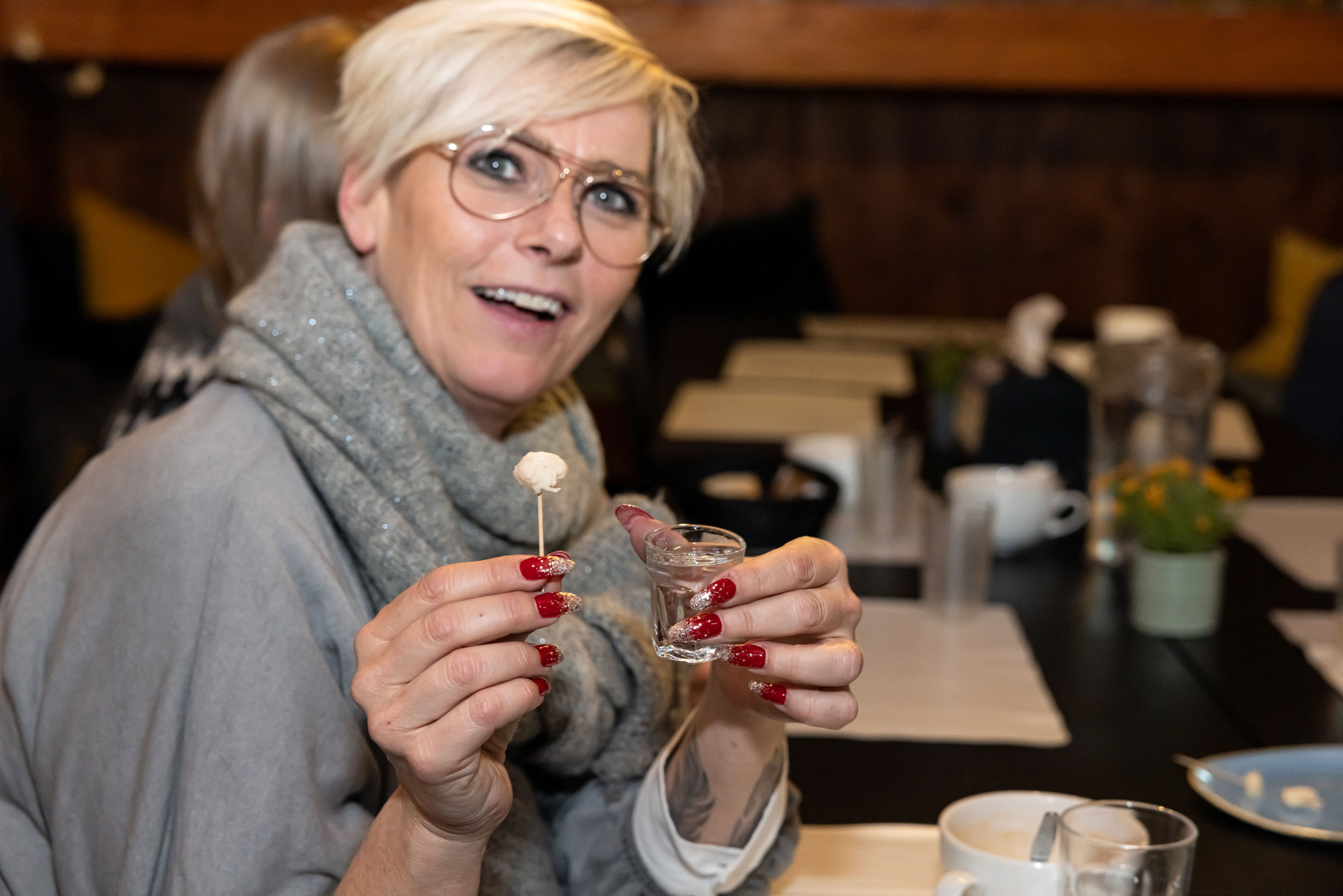 A guest showing off a bite of fermented shark