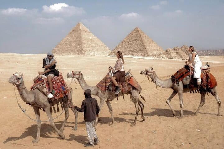 small-group tour enjoying camel ride with the view of the Pyramids