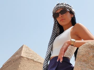 Relaxing at the Pyramid View: Tourist wearing sunglasses enjoying the view of the Great Pyramid of Giza.