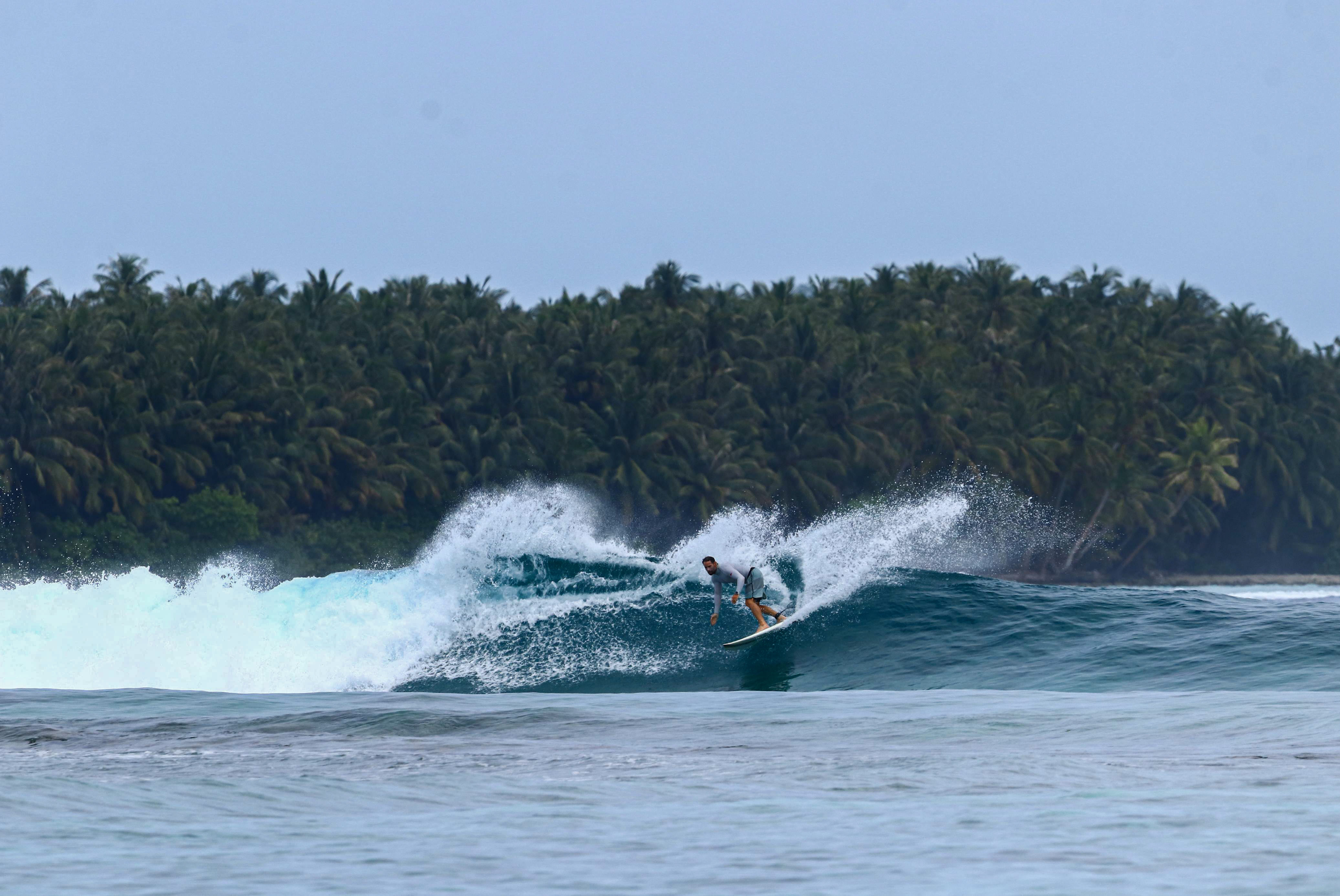 Beautiful shot of a surfer riding the waves at Honkeys, Himmafushi.