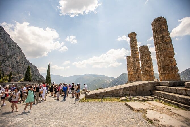 Delphi archaeological site walkway with visitor exploring ruins